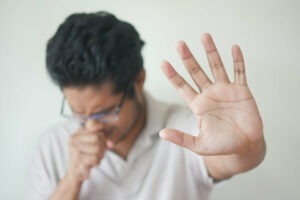homme qui met la met devant lui en faisant stop